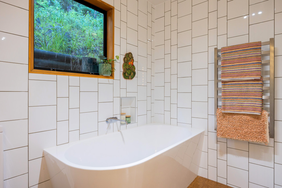 Small eclectic bathroom in Auckland with white cabinets, a corner tub, a corner shower, white tile, ceramic tile, white walls, cork floors, a wall-mount sink, brown floor, a hinged shower door, a single vanity and a floating vanity.
