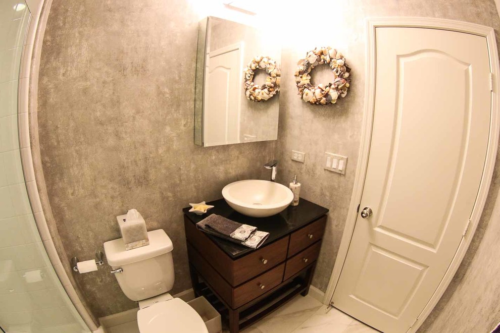 Photo of a small modern bathroom in San Diego with flat-panel cabinets, medium wood cabinets, an open shower, a two-piece toilet, black tile, porcelain tile, grey walls, porcelain floors, a vessel sink and granite benchtops.