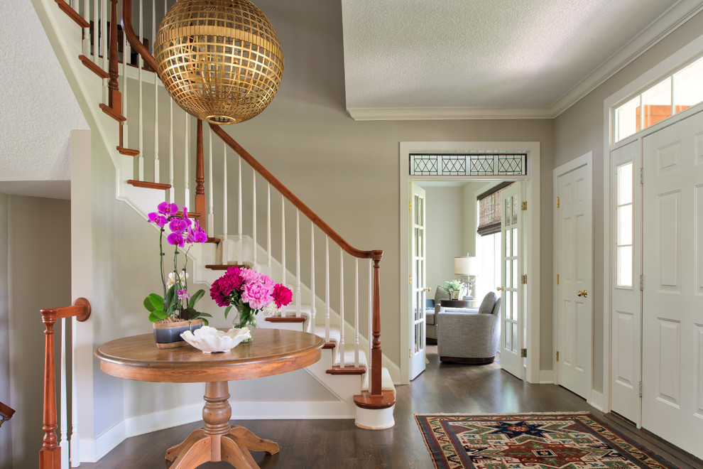 This is an example of a mid-sized transitional foyer in Minneapolis with beige walls, dark hardwood floors, a single front door, a white front door and brown floor.