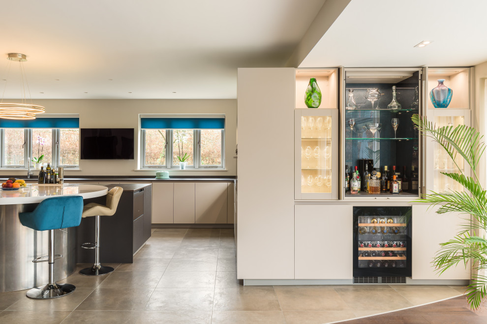 This is an example of a large contemporary u-shaped home bar in Sussex.
