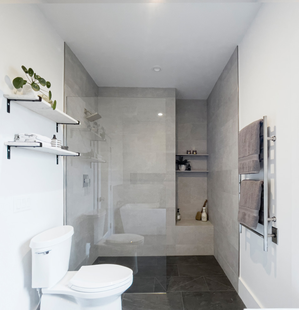 This is an example of a medium sized contemporary ensuite bathroom in San Francisco with a freestanding bath, a built-in shower, a two-piece toilet, grey tiles, ceramic tiles, white walls, ceramic flooring, grey floors, an open shower and a shower bench.
