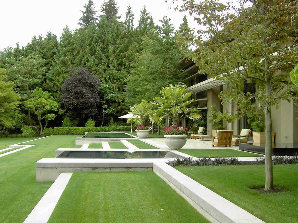This is an example of a traditional full sun garden in Seattle with a water feature.