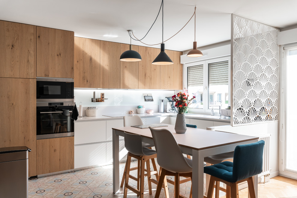 Inspiration for a mid-sized scandinavian eat-in kitchen in Lyon with quartzite benchtops, white splashback, glass sheet splashback, stainless steel appliances, cement tiles, no island, white benchtop, flat-panel cabinets, light wood cabinets and multi-coloured floor.