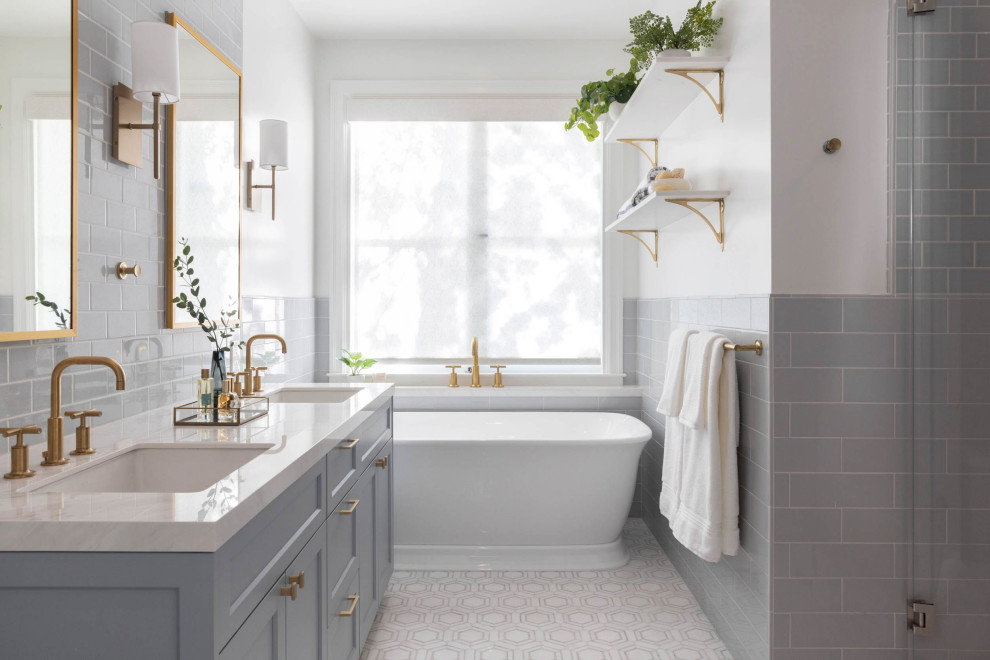 Inspiration för stora klassiska vitt en-suite badrum, med släta luckor, blå skåp, ett fristående badkar, en dusch i en alkov, grå kakel, glaskakel, vita väggar, klinkergolv i keramik, ett undermonterad handfat, marmorbänkskiva, vitt golv och dusch med gångjärnsdörr