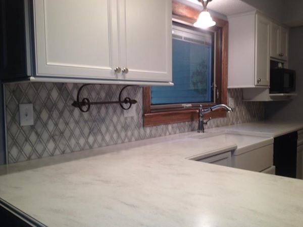 Example of a small transitional u-shaped eat-in kitchen design in Chicago with a farmhouse sink, recessed-panel cabinets, white cabinets, marble countertops, gray backsplash, mosaic tile backsplash, black appliances and a peninsula