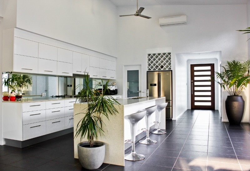 Inspiration for a large beach style single-wall eat-in kitchen in Cairns with a drop-in sink, white cabinets, mirror splashback, stainless steel appliances and with island.
