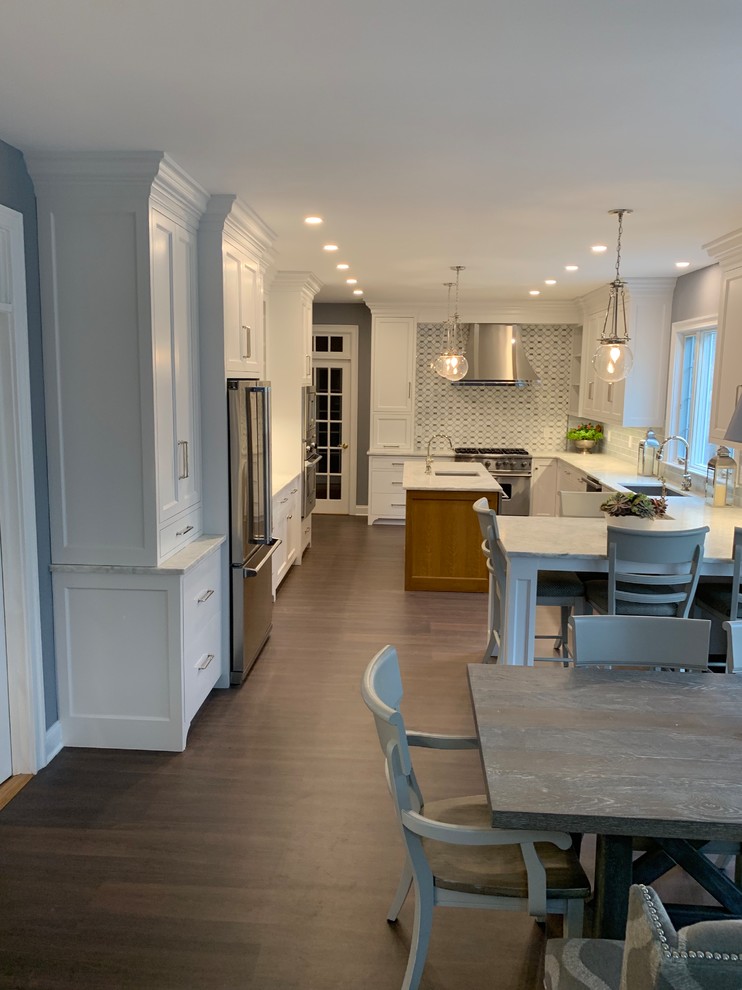 This is an example of an expansive traditional u-shaped eat-in kitchen in Other with a single-bowl sink, recessed-panel cabinets, white cabinets, quartzite benchtops, blue splashback, ceramic splashback, stainless steel appliances, cork floors, with island, brown floor and grey benchtop.