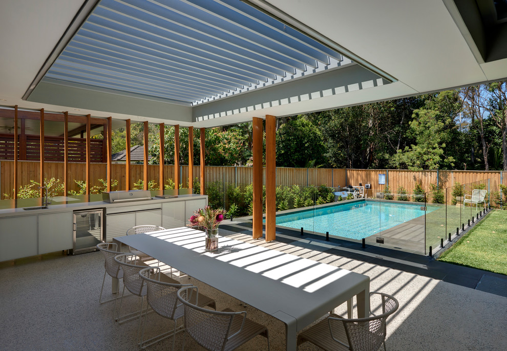 Inspiration for a mid-sized contemporary backyard patio in Sydney with an outdoor kitchen, a pergola and concrete slab.