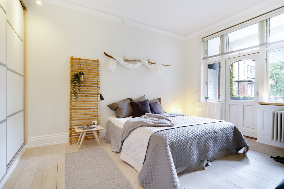 Design ideas for a large scandinavian master bedroom in Copenhagen with beige walls, light hardwood floors and beige floor.