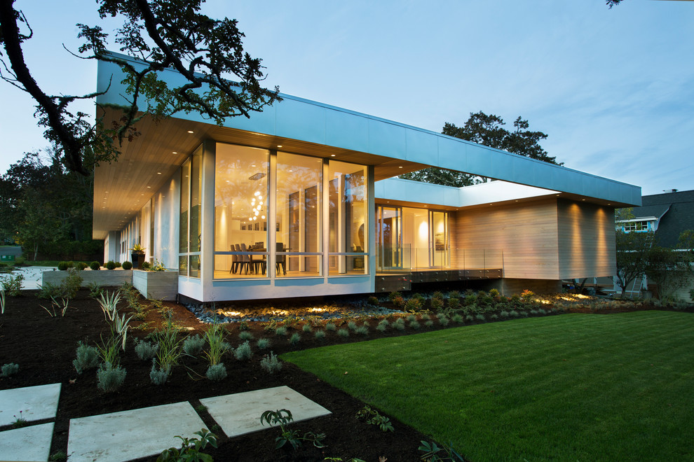 This is an example of a modern one-storey exterior in Vancouver with wood siding and a flat roof.