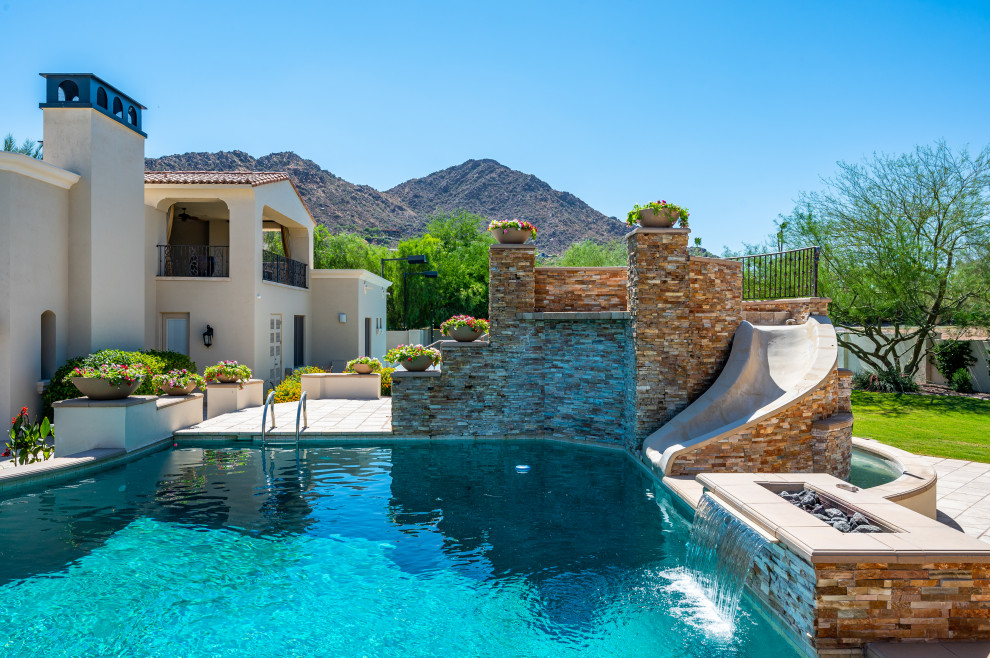 Inspiration for an expansive modern backyard custom-shaped lap pool in Phoenix with a water slide.