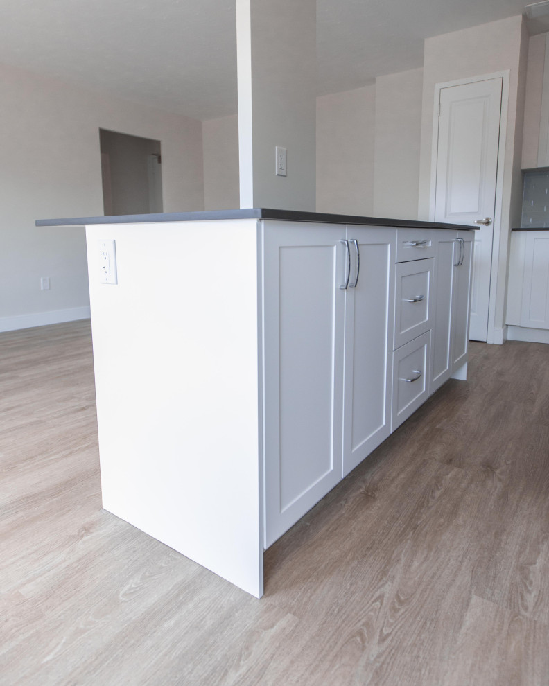 Photo of a medium sized modern l-shaped kitchen/diner in Toronto with beaded cabinets, white cabinets and an island.