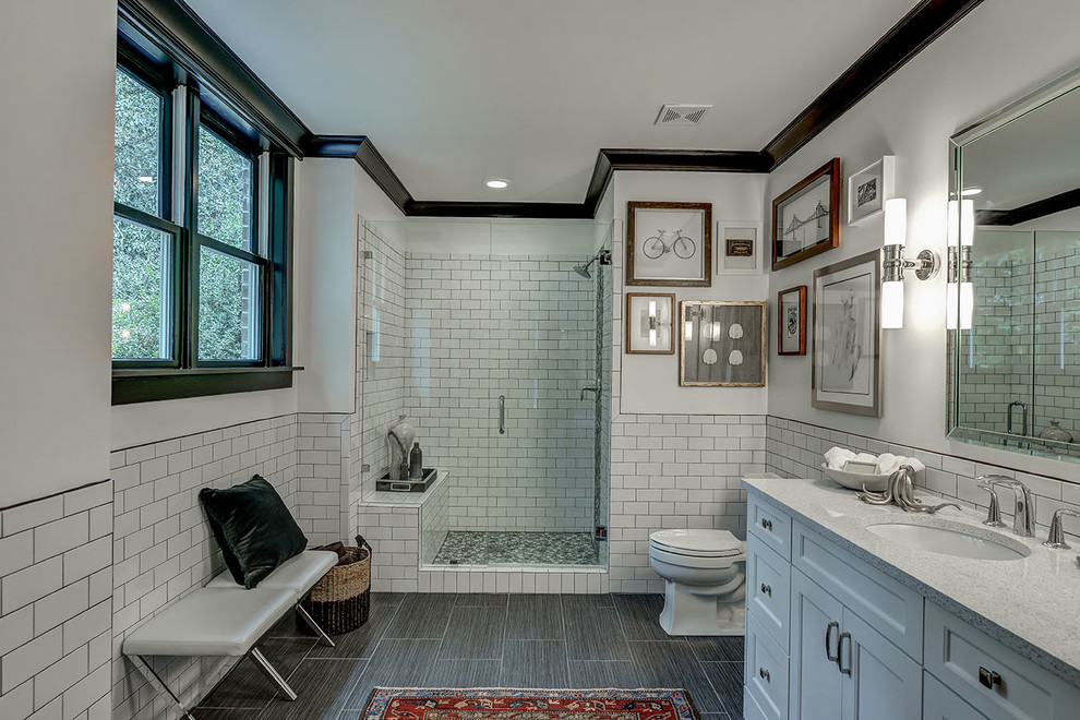 Inspiration for a traditional bathroom in Atlanta with recessed-panel cabinets, white cabinets, a one-piece toilet, white tile, subway tile, white walls, porcelain floors and an undermount sink.
