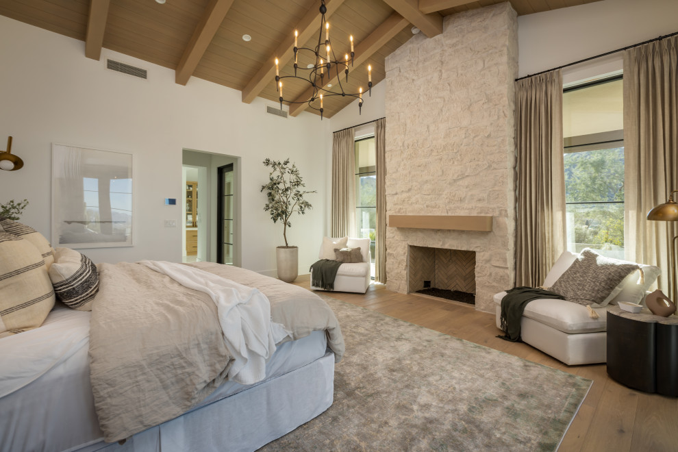 フェニックスにある広いトランジショナルスタイルのおしゃれな主寝室 (白い壁、淡色無垢フローリング、標準型暖炉、石材の暖炉まわり、ベージュの床、板張り天井、板張り壁)