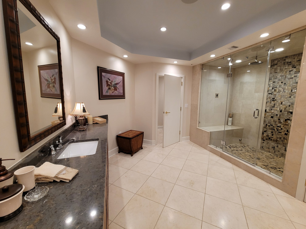 Photo of an expansive transitional master bathroom in Boston with louvered cabinets, medium wood cabinets, a double shower, a bidet, multi-coloured tile, mosaic tile, beige walls, travertine floors, an undermount sink, granite benchtops, white floor, a hinged shower door, grey benchtops, an enclosed toilet, a double vanity, a built-in vanity and recessed.