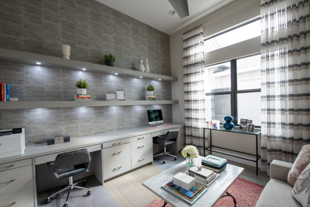 Cette photo montre un bureau tendance avec un mur blanc, parquet clair, aucune cheminée, un bureau intégré, un sol beige et du papier peint.