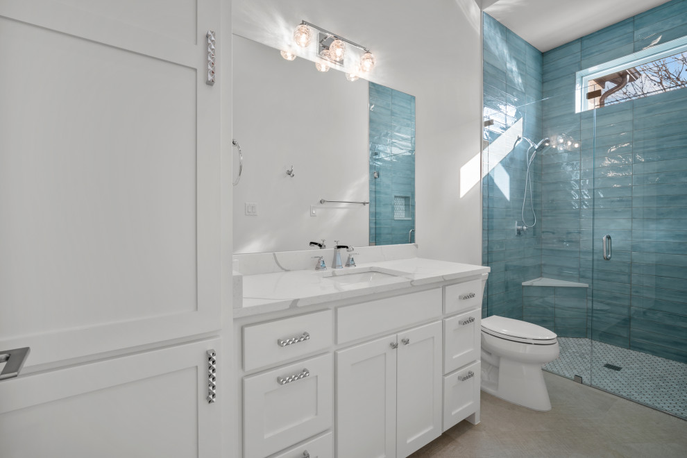 ダラスにある高級な中くらいなモダンスタイルのおしゃれなバスルーム (浴槽なし) (落し込みパネル扉のキャビネット、白いキャビネット、アルコーブ型シャワー、一体型トイレ	、青いタイル、サブウェイタイル、白い壁、セラミックタイルの床、アンダーカウンター洗面器、珪岩の洗面台、グレーの床、開き戸のシャワー、白い洗面カウンター、トイレ室、洗面台1つ、造り付け洗面台) の写真