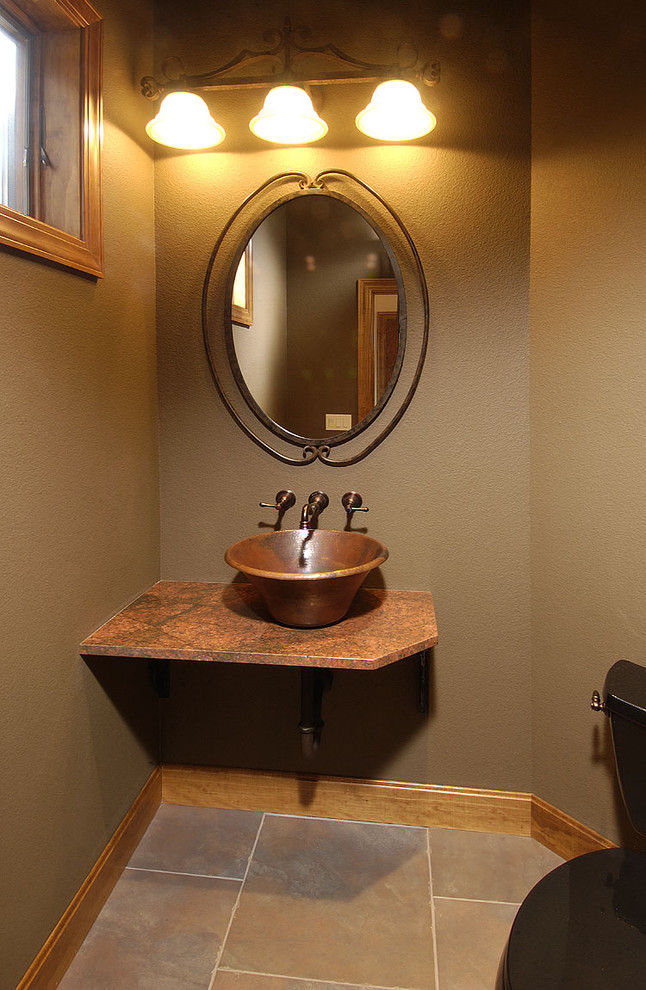 This is an example of a small country powder room in Denver with a two-piece toilet, brown walls, a vessel sink and granite benchtops.
