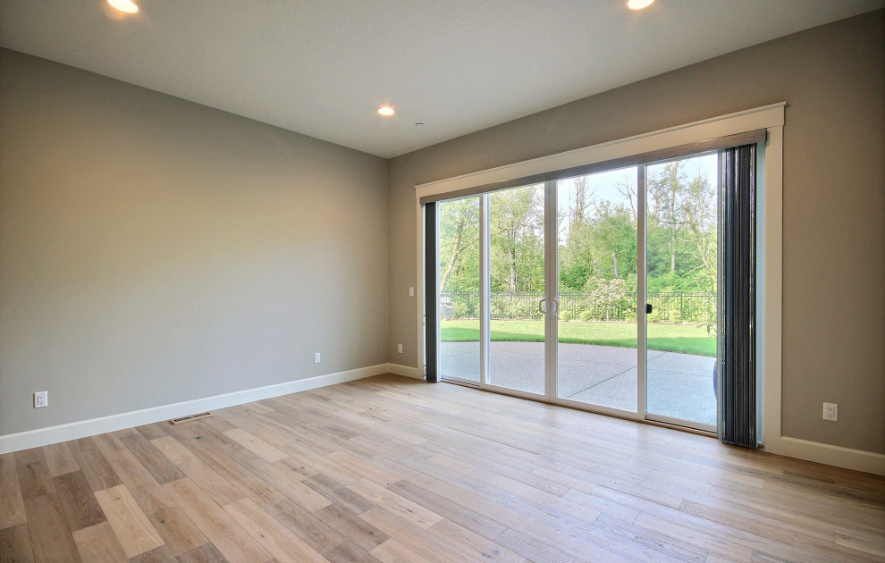 Design ideas for a large modern home yoga studio in Portland with beige walls, light hardwood floors and brown floor.