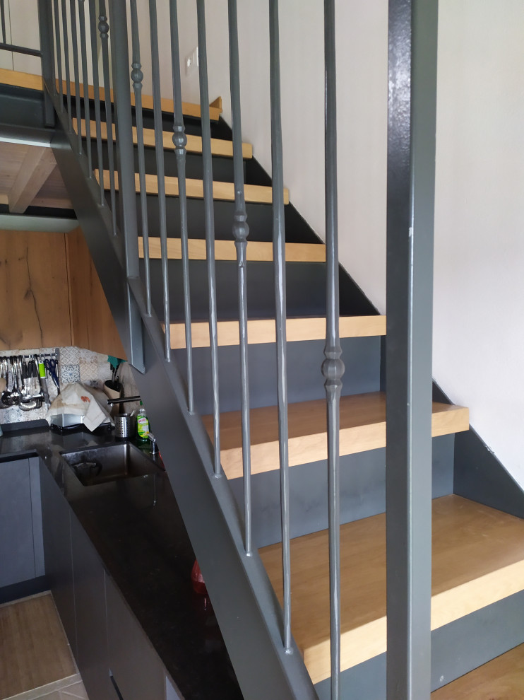 Idées déco pour un escalier contemporain en L de taille moyenne avec des marches en bois, des contremarches en métal et un garde-corps en métal.