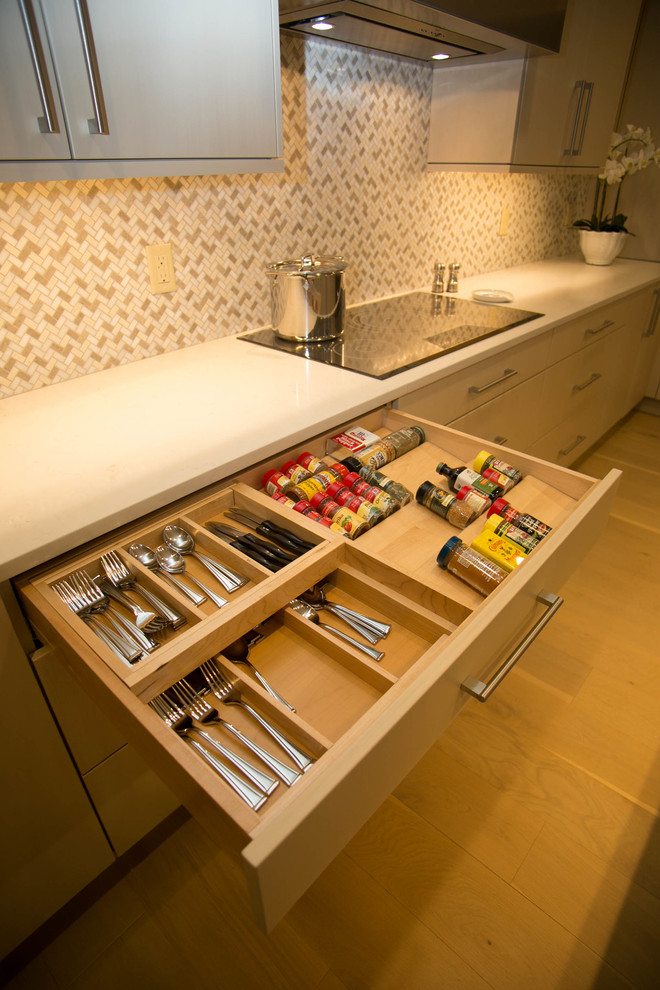 Mid-sized transitional l-shaped light wood floor kitchen photo in New Orleans with an undermount sink, flat-panel cabinets, beige cabinets, multicolored backsplash, mosaic tile backsplash, stainless steel appliances and an island