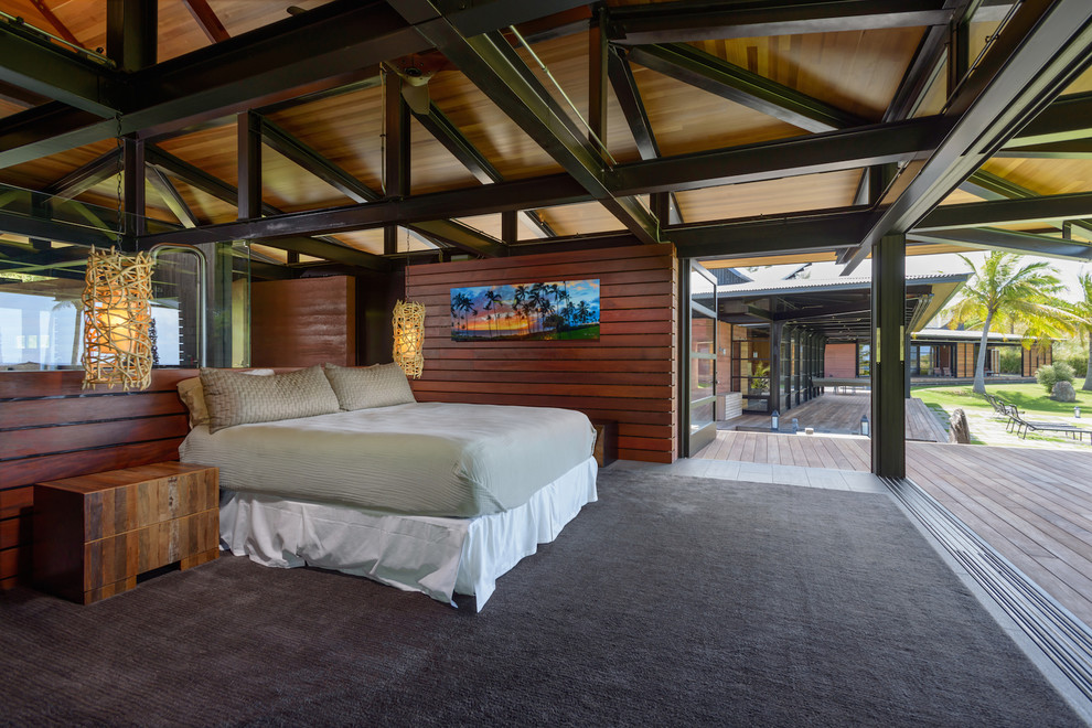 Contemporary bedroom in Hawaii with brown walls and carpet.