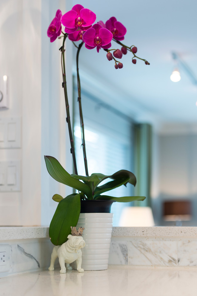 Inspiration for a mid-sized transitional l-shaped medium tone wood floor open concept kitchen remodel in Vancouver with an undermount sink, shaker cabinets, white cabinets, quartz countertops, white backsplash, stone tile backsplash, stainless steel appliances and an island