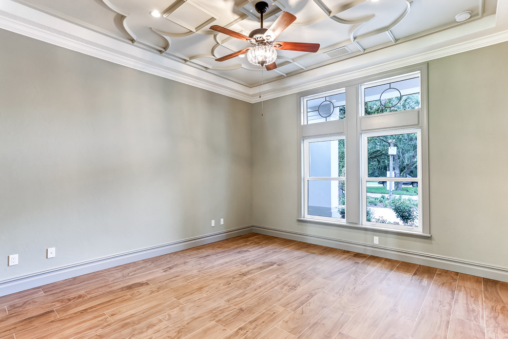 Large transitional home office in Tampa with grey walls, medium hardwood floors, no fireplace and brown floor.