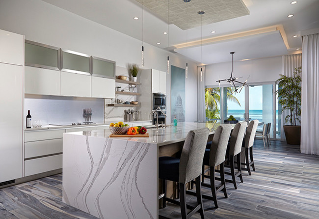 This is an example of a large contemporary open plan kitchen in Miami with flat-panel cabinets, beige cabinets, with island, an undermount sink, quartz benchtops, stainless steel appliances, dark hardwood floors and black floor.