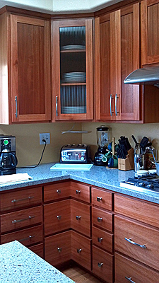 Kitchen - brown floor kitchen idea with an integrated sink, shaker cabinets, stainless steel appliances and an island