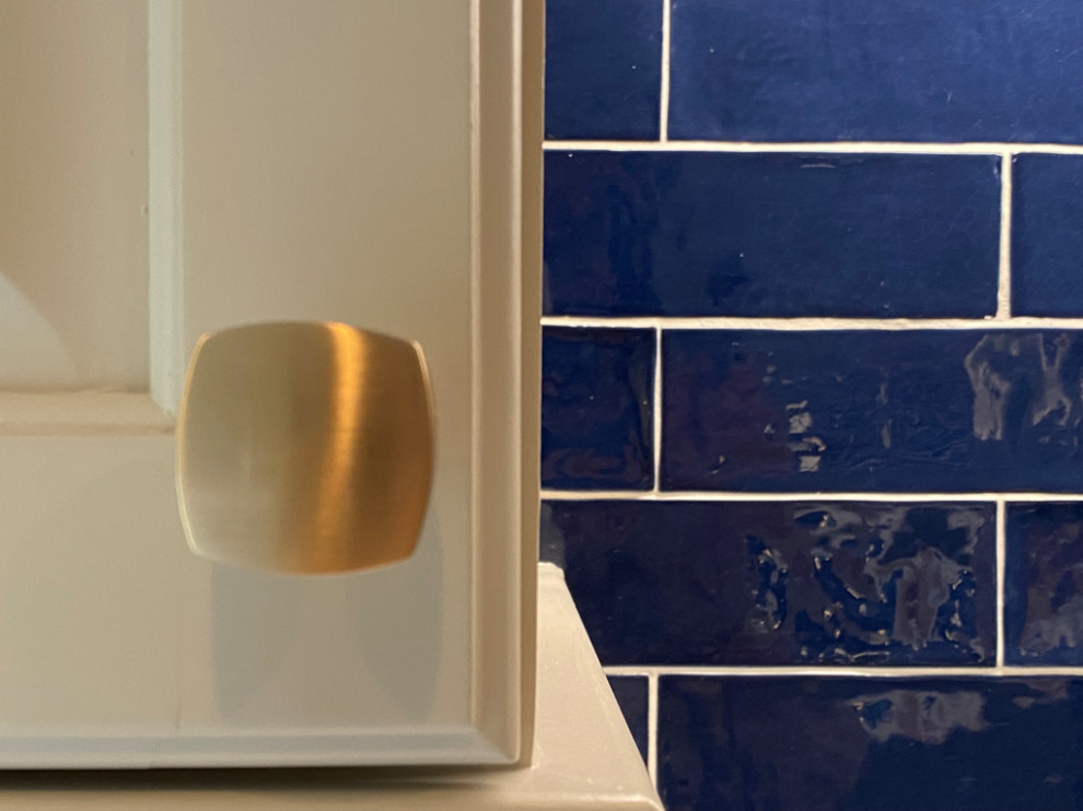 Cette image montre une cuisine parallèle bohème de taille moyenne avec un évier 1 bac, un placard avec porte à panneau encastré, une crédence bleue, une crédence en céramique, un sol en carrelage de porcelaine, un sol gris et un plan de travail gris.