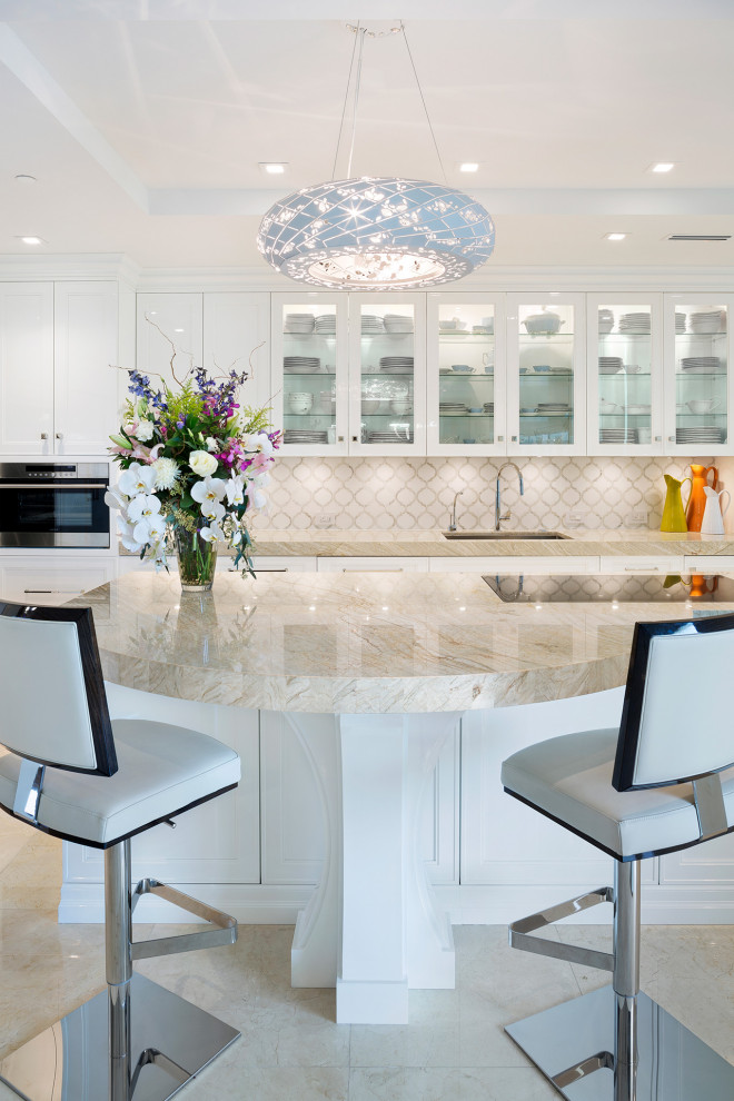 Inspiration for a mid-sized transitional l-shaped porcelain tile and beige floor eat-in kitchen remodel in Miami with an undermount sink, recessed-panel cabinets, white cabinets, marble countertops, beige backsplash, mosaic tile backsplash, stainless steel appliances, an island and beige countertops