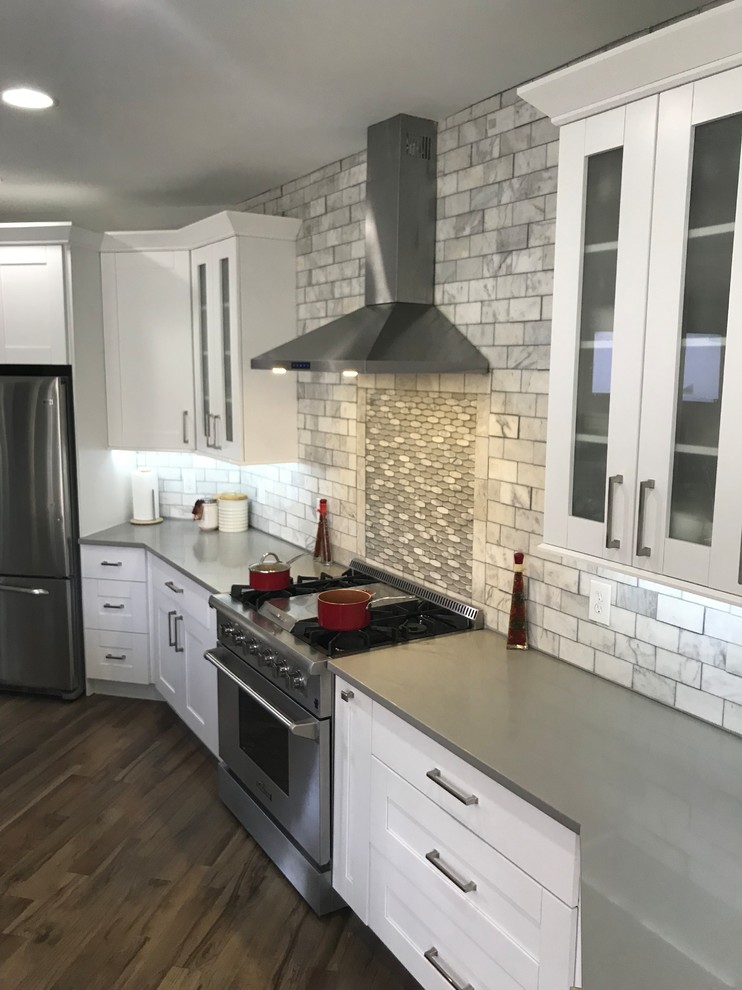 Example of a large transitional single-wall light wood floor and gray floor eat-in kitchen design in Atlanta with a farmhouse sink, shaker cabinets, white cabinets, quartzite countertops, white backsplash, marble backsplash, stainless steel appliances, an island and white countertops