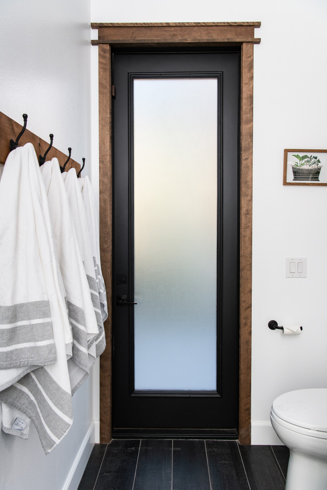 Cette image montre une douche en alcôve méditerranéenne avec des portes de placard blanches, un mur blanc, un sol en carrelage de porcelaine, une vasque, un plan de toilette en quartz, un sol noir, une cabine de douche à porte battante, un plan de toilette noir, un banc de douche, meuble simple vasque et meuble-lavabo encastré.