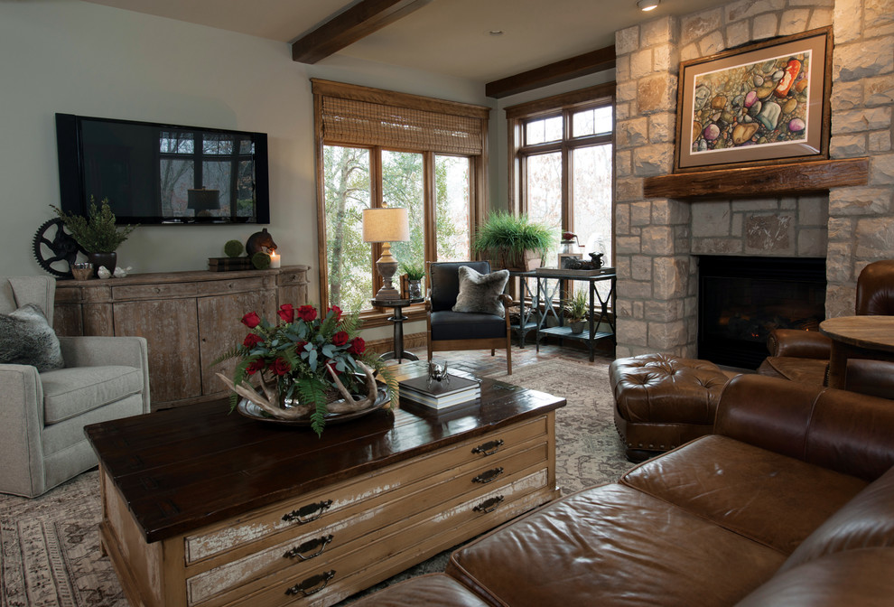 Photo of a mid-sized traditional enclosed family room in Other with beige walls, medium hardwood floors, a standard fireplace, a stone fireplace surround and a wall-mounted tv.