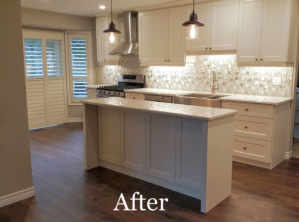 Large transitional galley laminate floor and brown floor kitchen pantry photo in Toronto with a farmhouse sink, recessed-panel cabinets, white cabinets, quartzite countertops, gray backsplash, mosaic tile backsplash, an island and white countertops