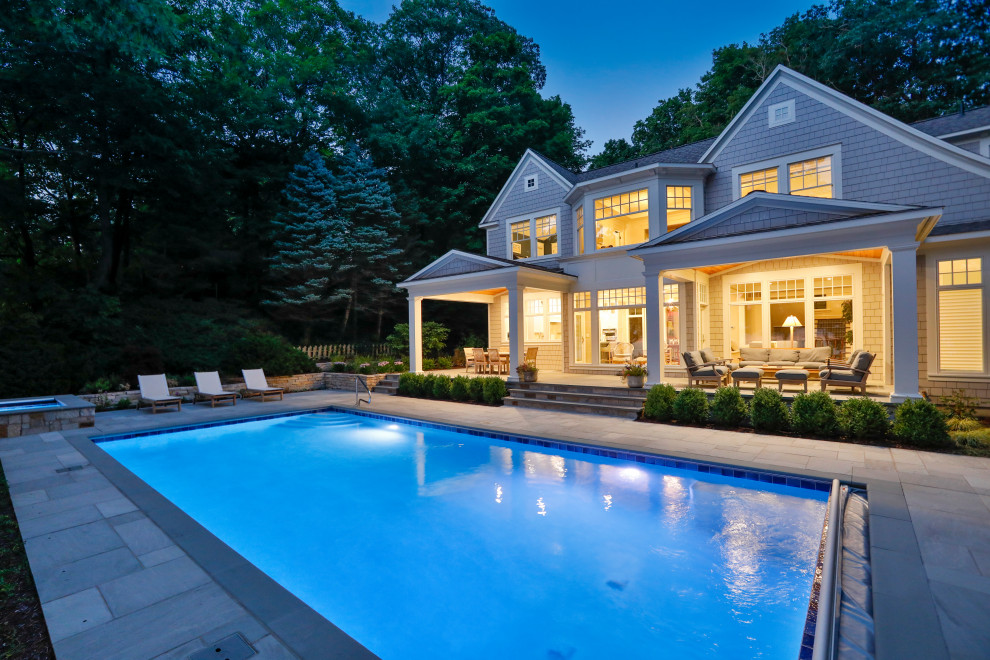 Imagen de piscina alargada clásica de tamaño medio rectangular en patio trasero con privacidad y adoquines de piedra natural