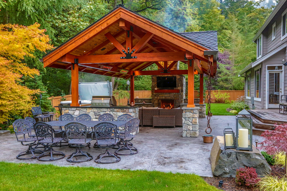Inspiration for a mid-sized arts and crafts courtyard patio in Seattle with with fireplace, stamped concrete and a gazebo/cabana.