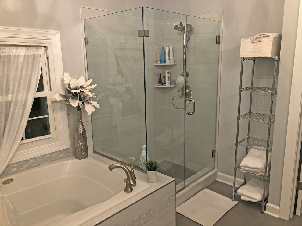 Photo of a mid-sized transitional master bathroom in Baltimore with shaker cabinets, white cabinets, a drop-in tub, a corner shower, a two-piece toilet, gray tile, marble, grey walls, an undermount sink, engineered quartz benchtops, yellow floor, a sliding shower screen, white benchtops, an enclosed toilet, a double vanity and a built-in vanity.