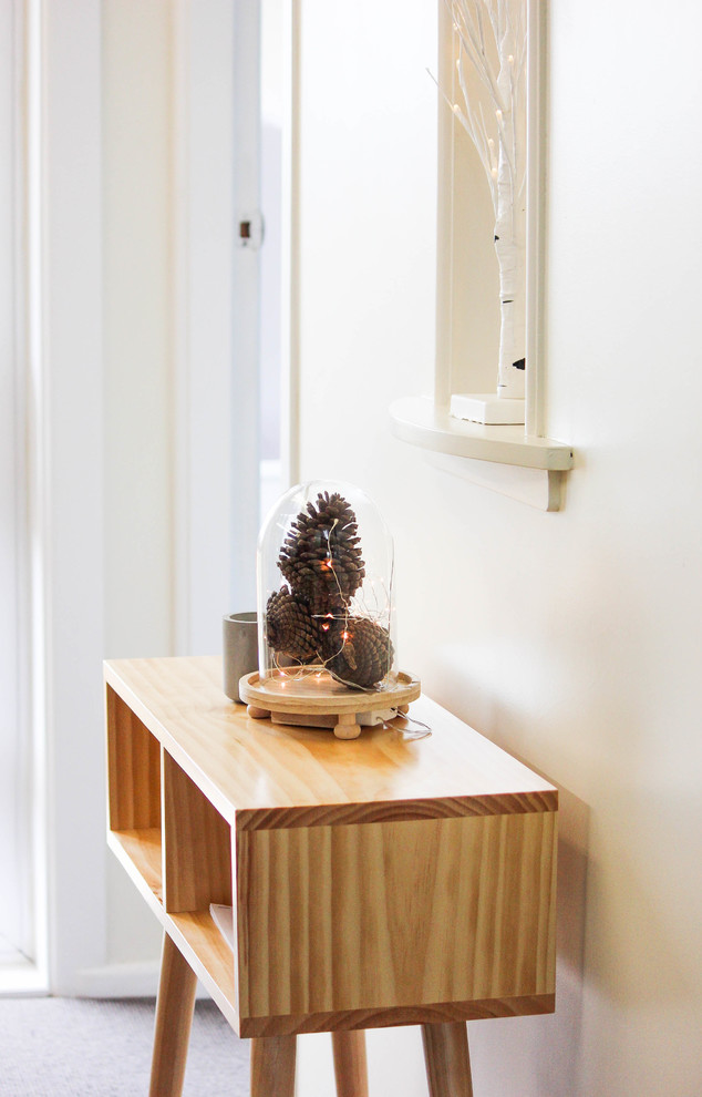 Photo of a small scandinavian foyer in Auckland with white walls and carpet.