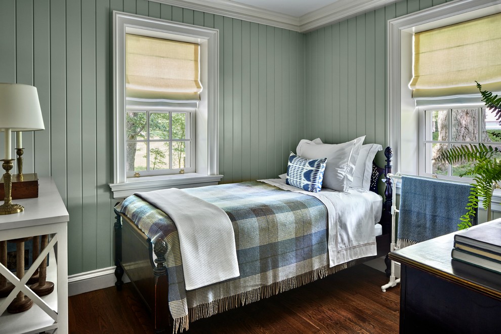 This is an example of a mid-sized traditional guest bedroom in New York with green walls, dark hardwood floors, no fireplace and brown floor.