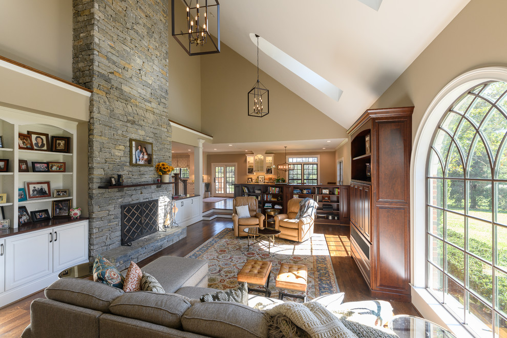 Photo of a traditional open concept living room in Other with brown walls, dark hardwood floors, a standard fireplace, a stone fireplace surround and brown floor.