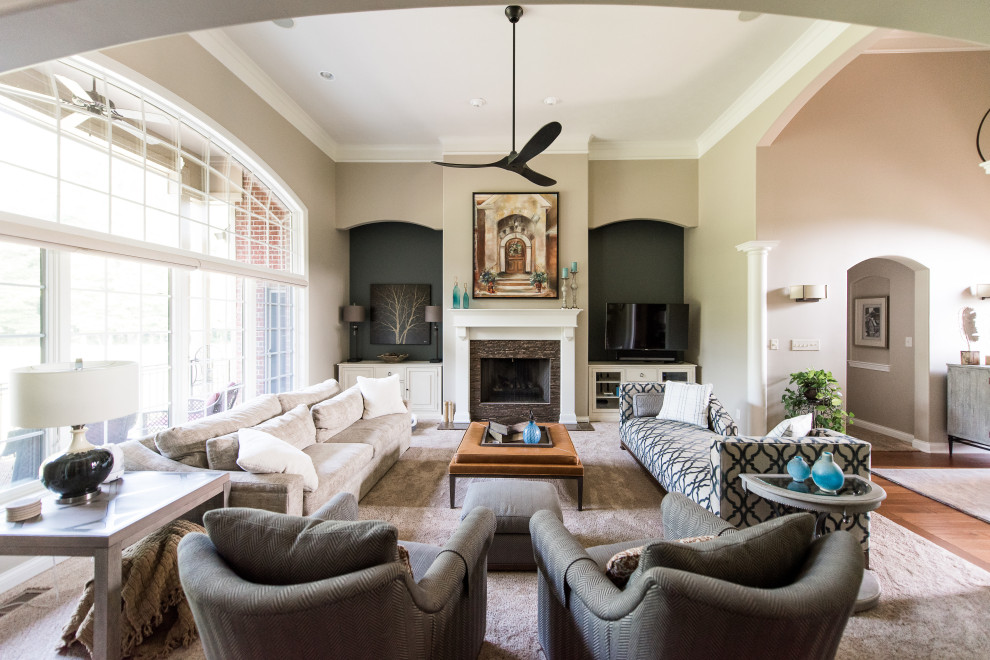 This is an example of a mid-sized modern formal open concept living room in Indianapolis with beige walls, medium hardwood floors, a standard fireplace, a stone fireplace surround and a corner tv.