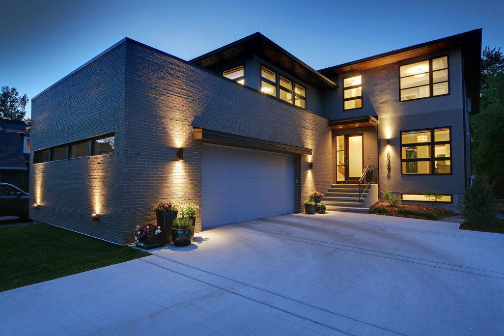 Large transitional two-story stucco gray home design photo in Calgary with a hip roof and a shingle roof