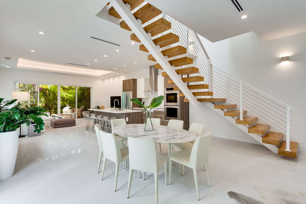 Large contemporary open plan dining in Miami with white walls, ceramic floors, no fireplace and white floor.