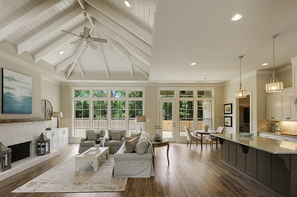 Design ideas for an expansive traditional open concept family room in New Orleans with beige walls, medium hardwood floors, a standard fireplace, a brick fireplace surround and no tv.