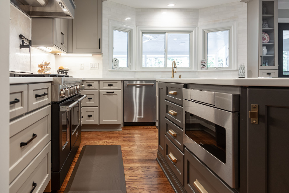 Design ideas for an expansive contemporary eat-in kitchen in Atlanta with a farmhouse sink, shaker cabinets, quartz benchtops, white splashback, marble splashback, stainless steel appliances, medium hardwood floors, with island and white benchtop.