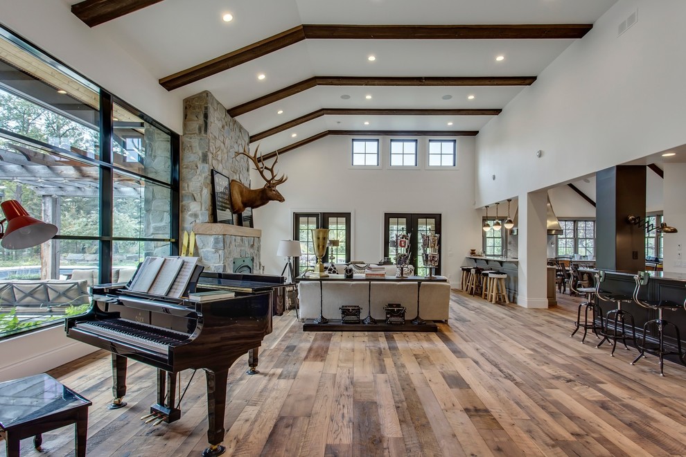 Design ideas for an expansive country open concept family room in Calgary with a music area, white walls, medium hardwood floors, a wood stove, a stone fireplace surround, no tv and multi-coloured floor.