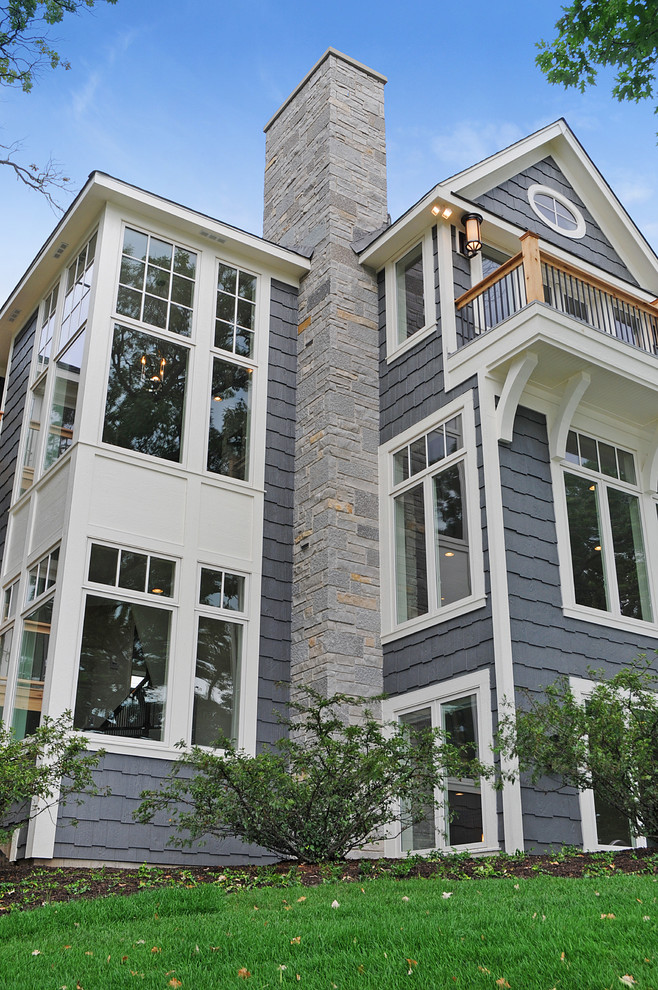 Large traditional three-storey grey exterior in Chicago with wood siding and a gable roof.
