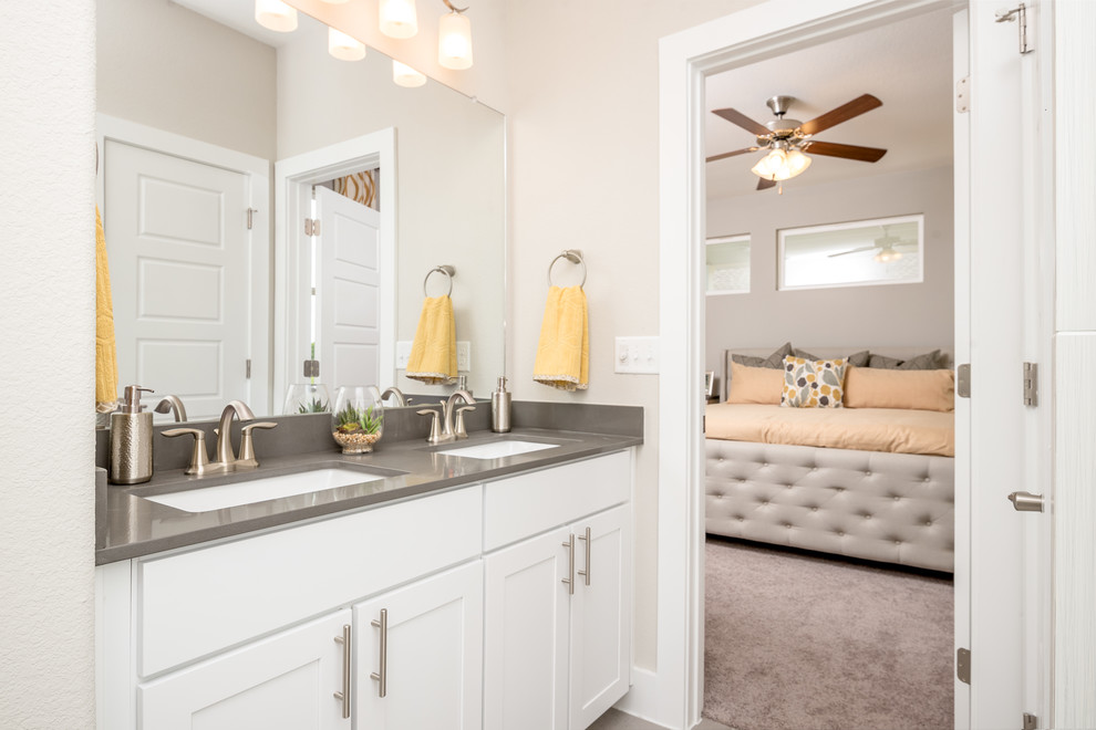 Mid-sized contemporary master bathroom in Austin with shaker cabinets, white cabinets, an alcove tub, an alcove shower, a one-piece toilet, white tile, ceramic tile, white walls, ceramic floors, an undermount sink and solid surface benchtops.